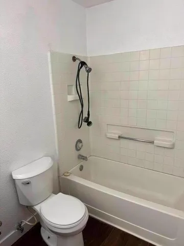 a white toilet and tub sitting next to a bathroom sink