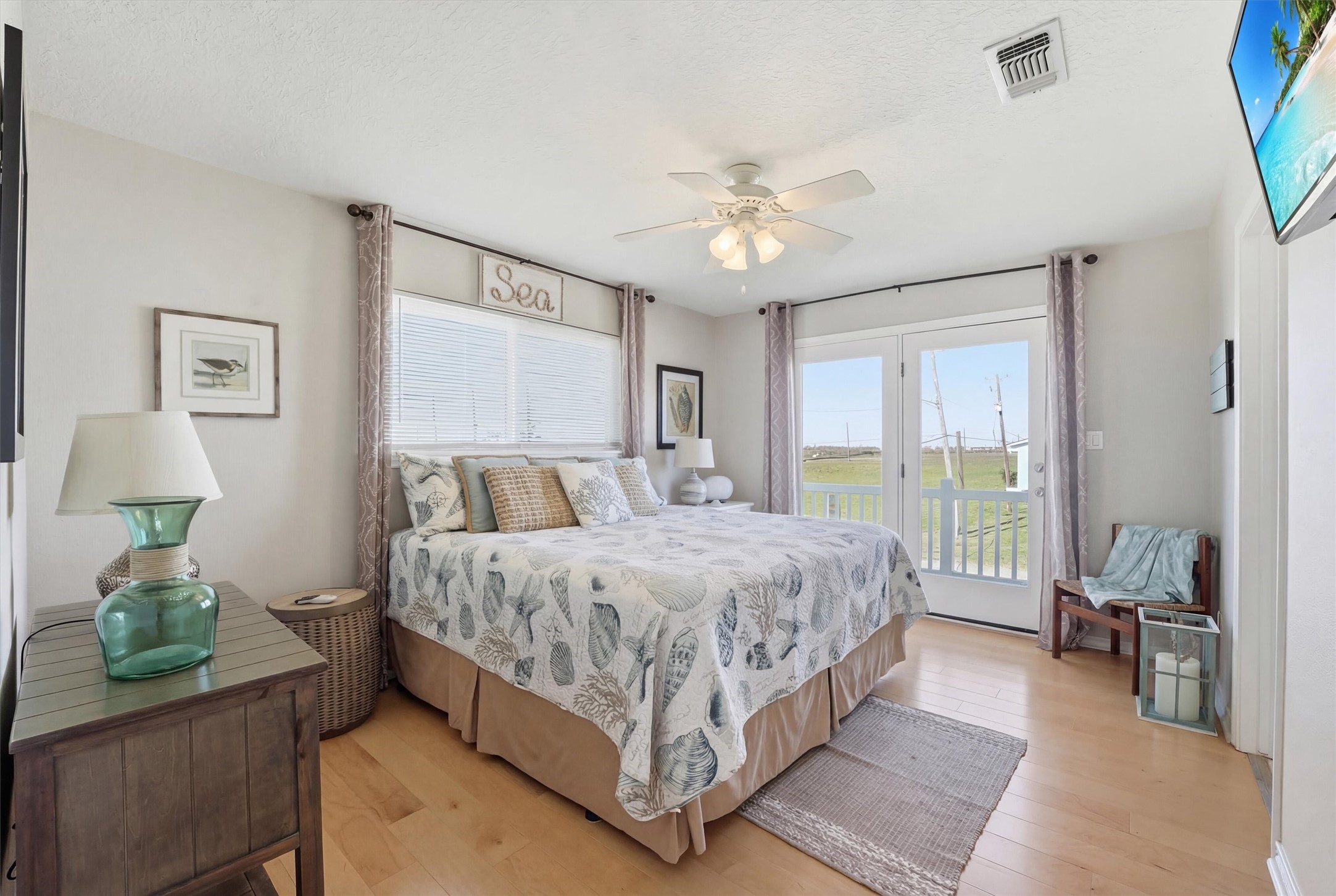 12902 John Reynolds Road Galveston, TX 77554 - Photo 11 of 22 a spacious bedroom with a bed and a chandelier