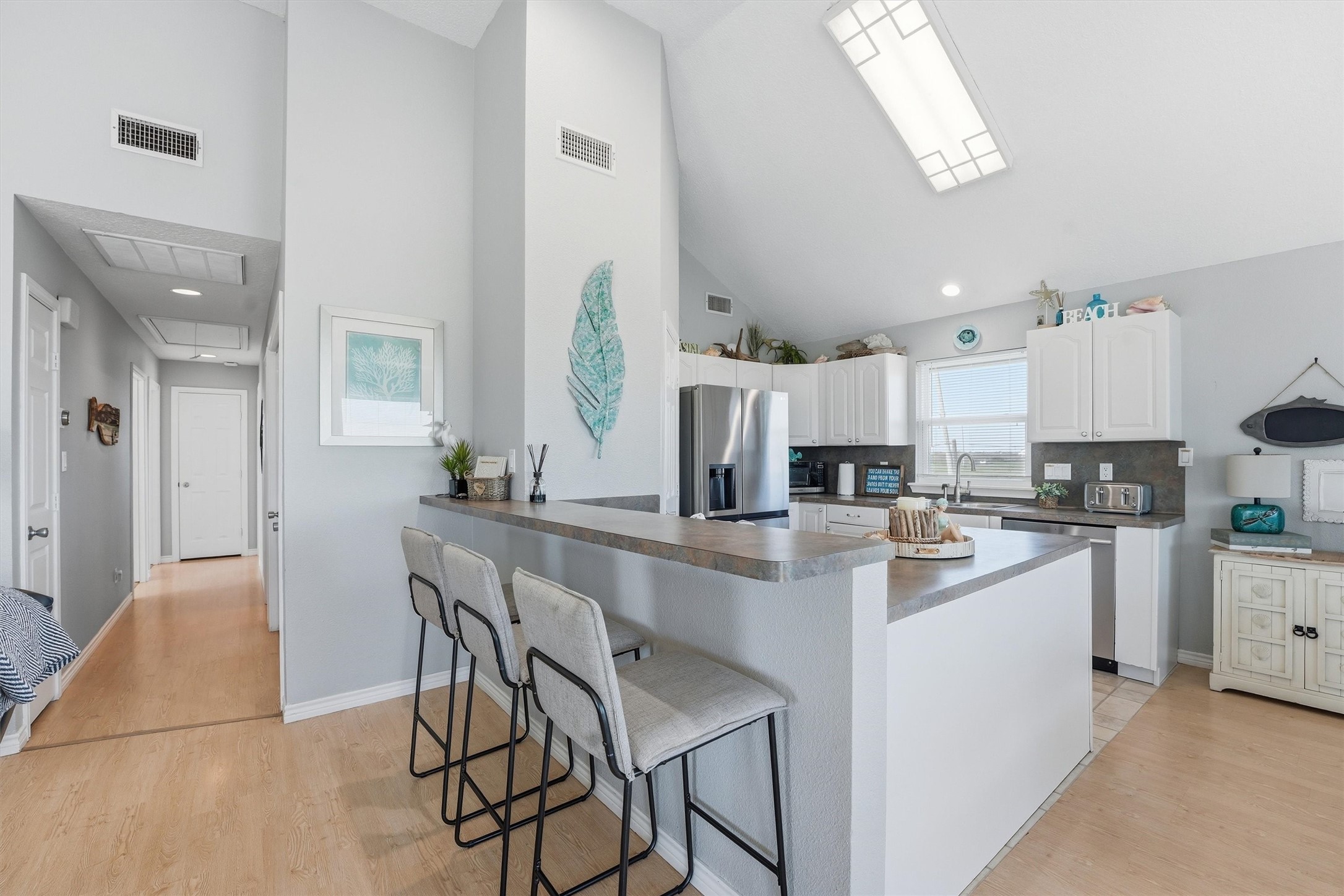 12902 John Reynolds Road Galveston, TX 77554 - Photo 5 of 22 a kitchen with a table chairs refrigerator and cabinets