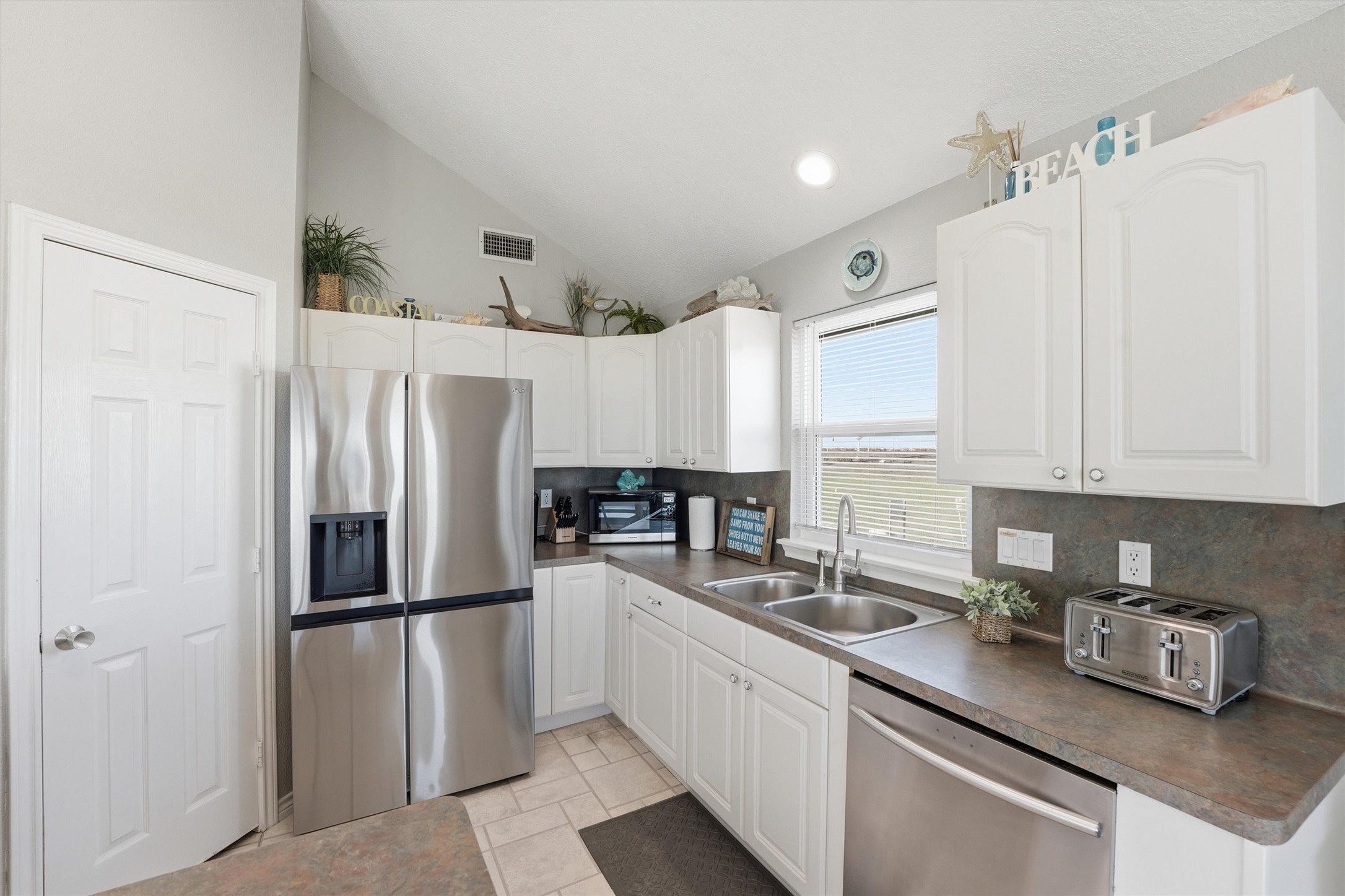 12902 John Reynolds Road Galveston, TX 77554 - Photo 6 of 22 a kitchen with stainless steel appliances a refrigerator sink and cabinets