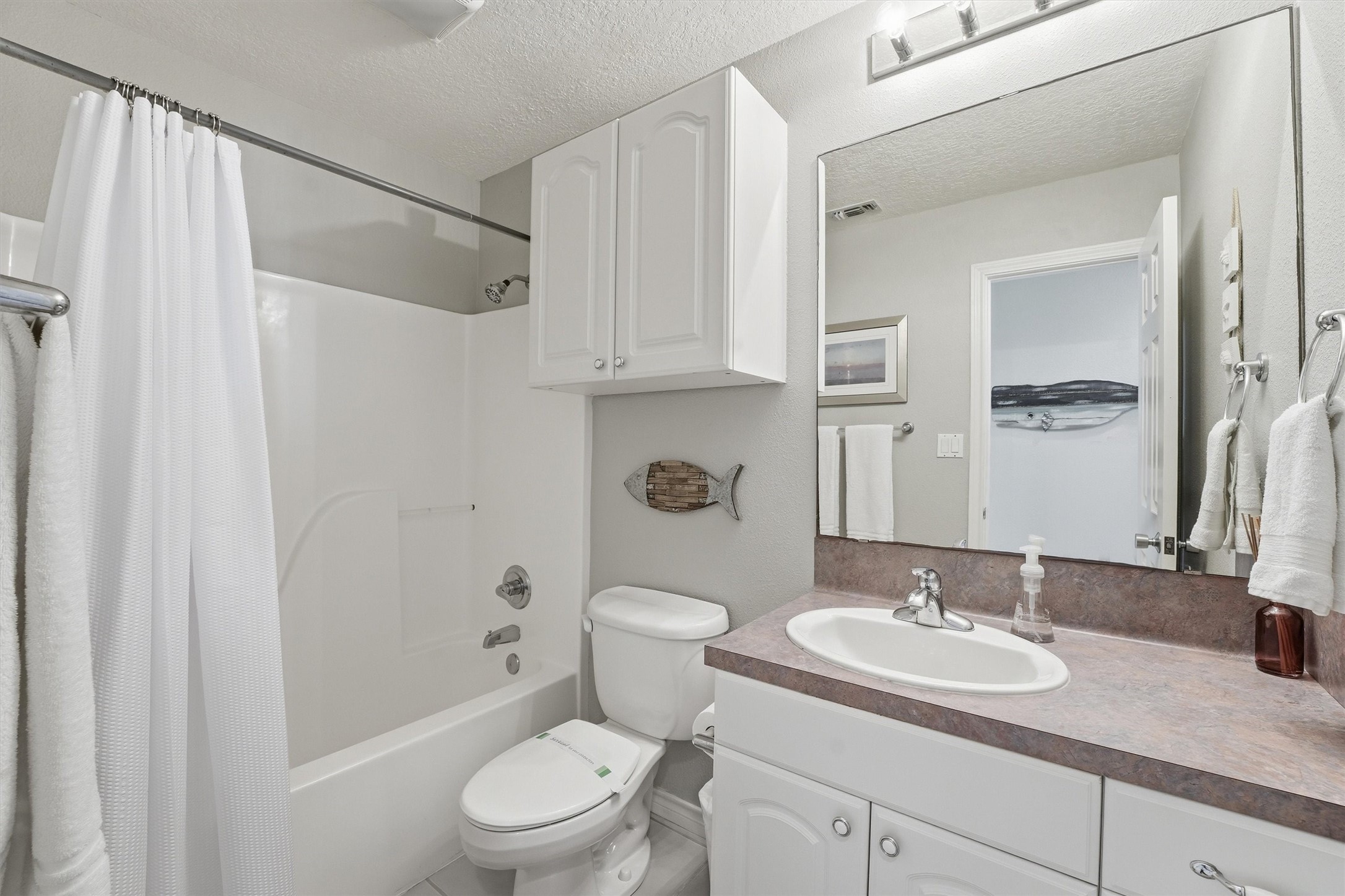 12902 John Reynolds Road Galveston, TX 77554 - Photo 10 of 22 a bathroom with a granite countertop sink toilet and shower
