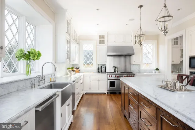 a kitchen with kitchen island granite countertop a sink appliances cabinets and a counter top space