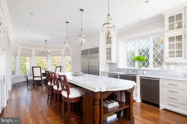 a view of a dining room and livingroom with furniture wooden floor a chandelier