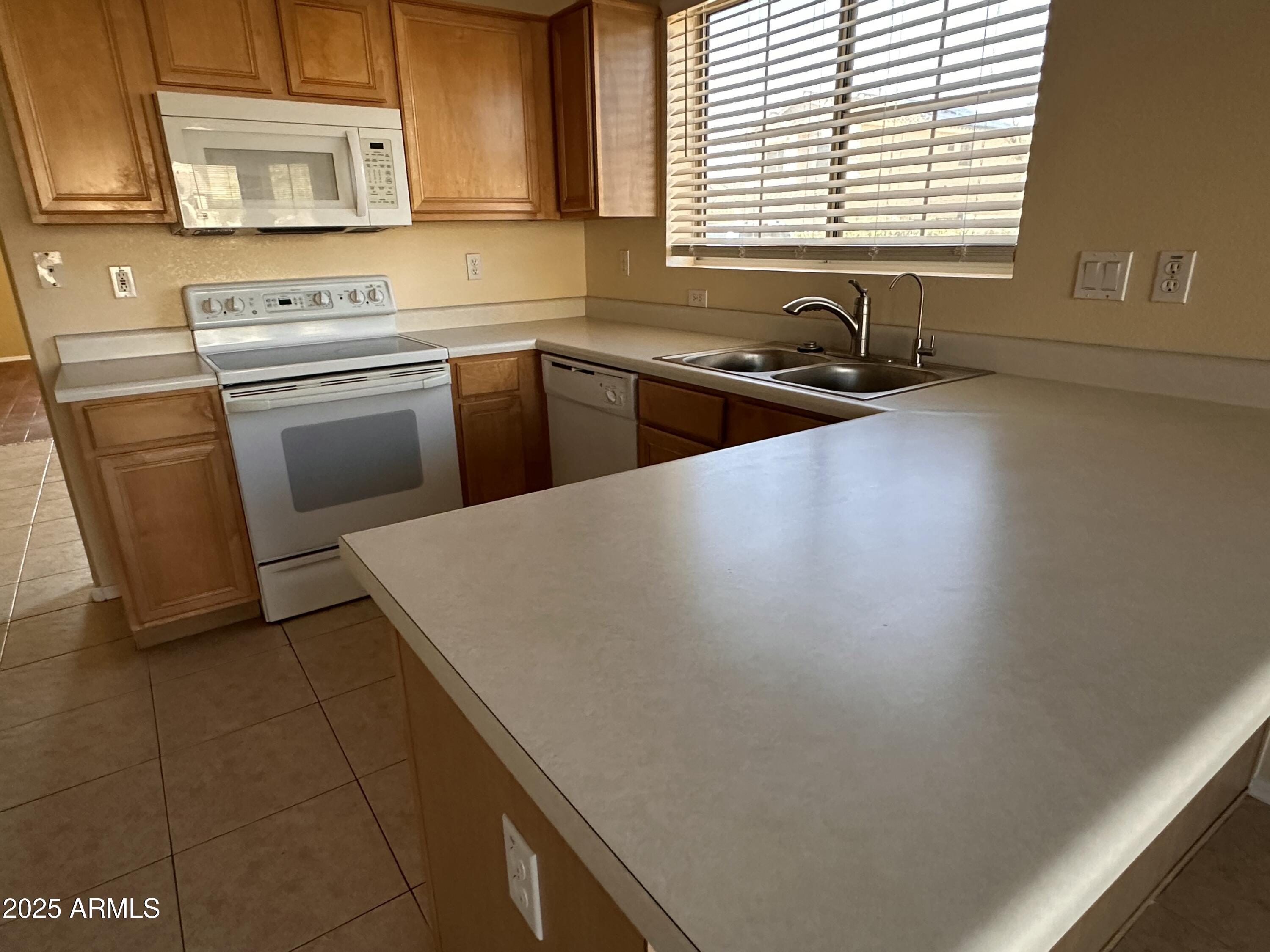 25412 North 40th Lane Phoenix, AZ 85083 - Photo 14 of 19 a kitchen with a sink a stove and cabinets