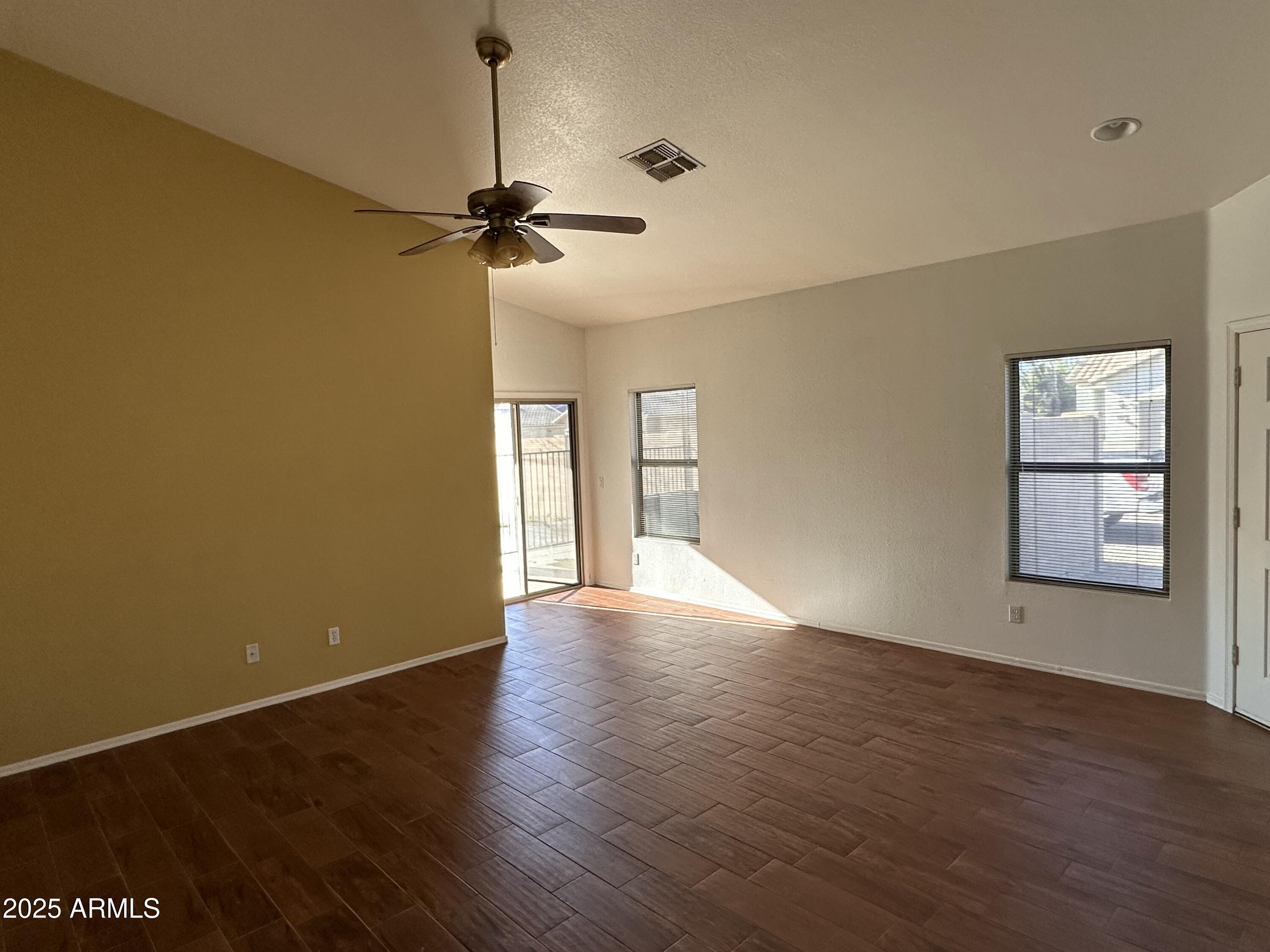 25412 North 40th Lane Phoenix, AZ 85083 - Photo 3 of 19 a view of empty room with wooden floor and fan