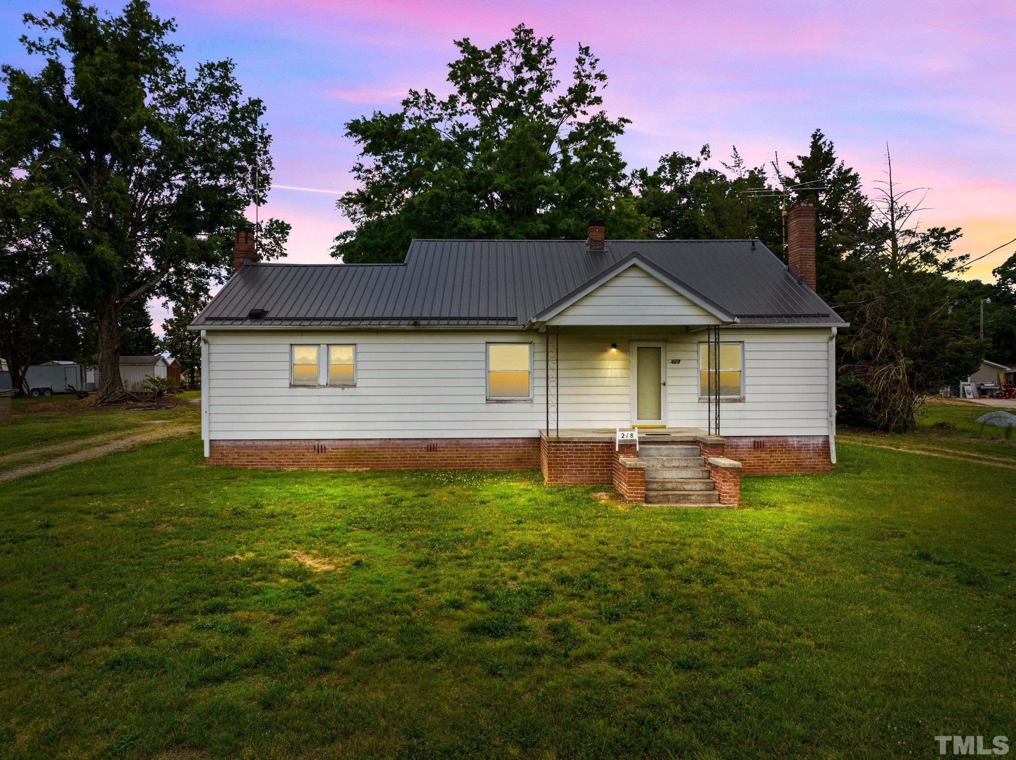 218 Oxford Road Roxboro, NC 27573 - Photo 1 of 16 a front view of a house with a garden