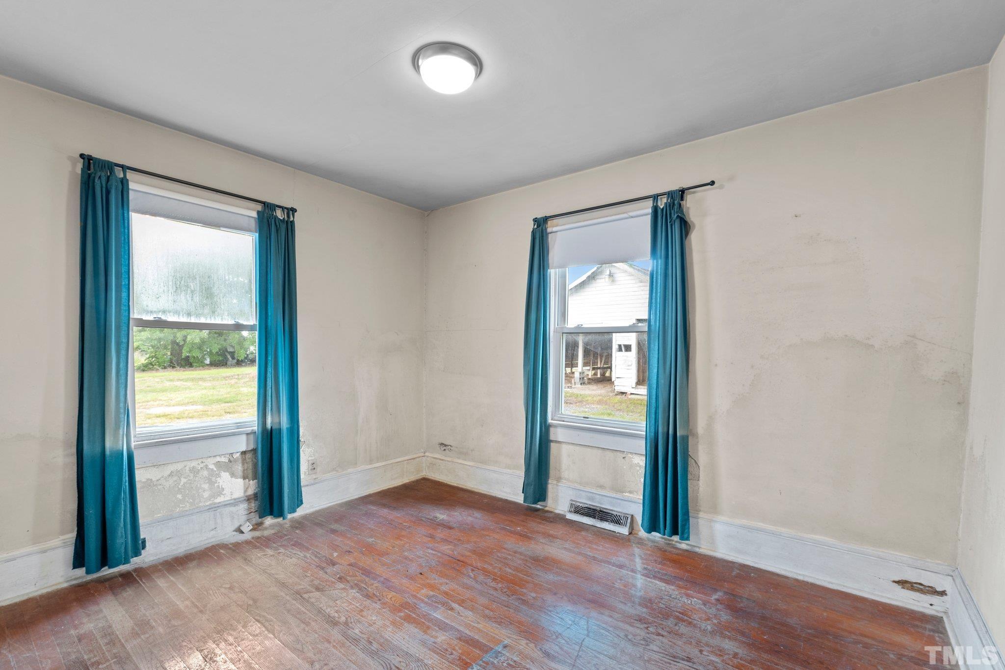 218 Oxford Road Roxboro, NC 27573 - Photo 12 of 16 an empty room with wooden floor and windows
