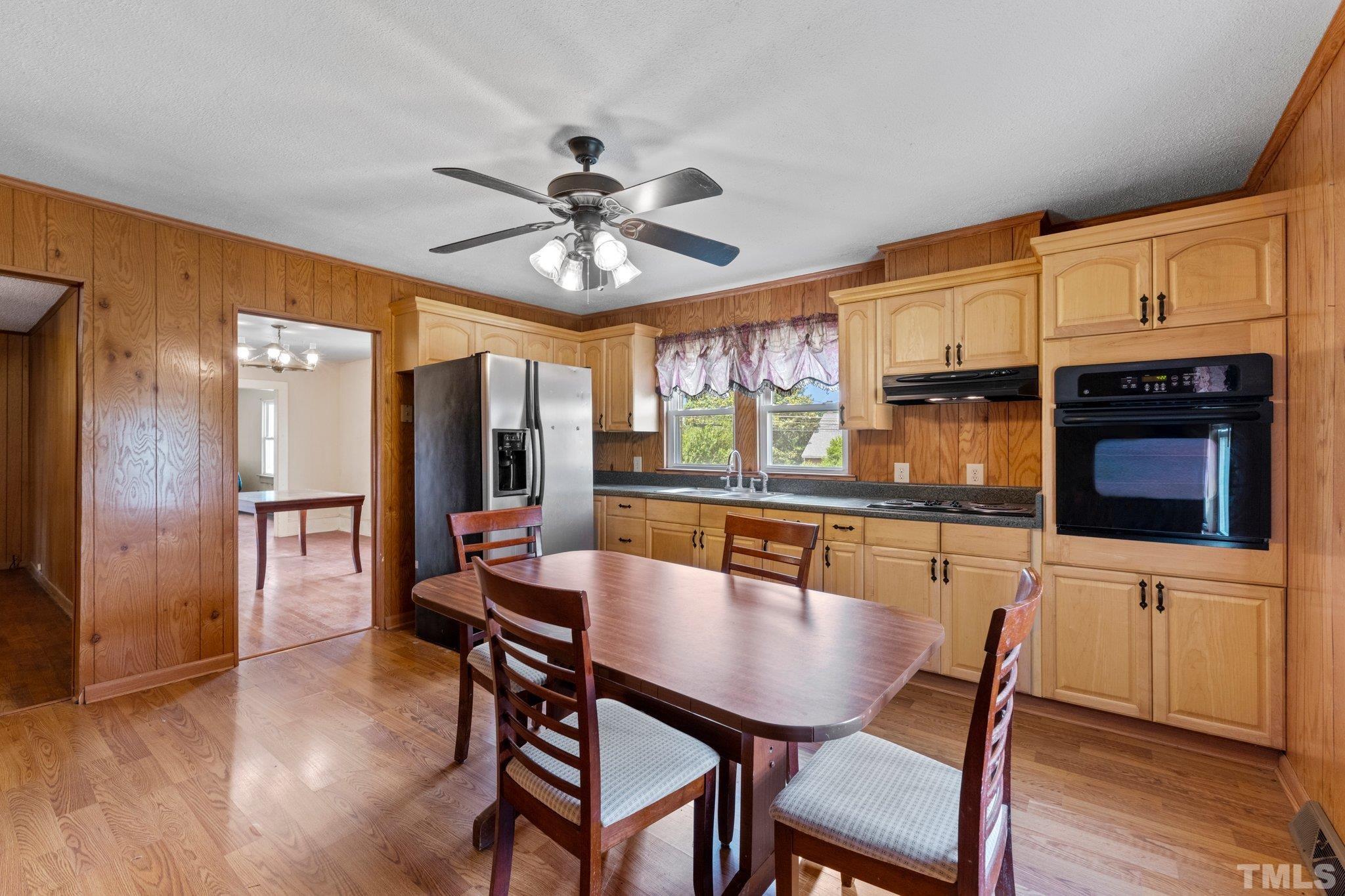 218 Oxford Road Roxboro, NC 27573 - Photo 4 of 16 a dining room with stainless steel appliances kitchen island granite countertop a dining table chairs and a large window
