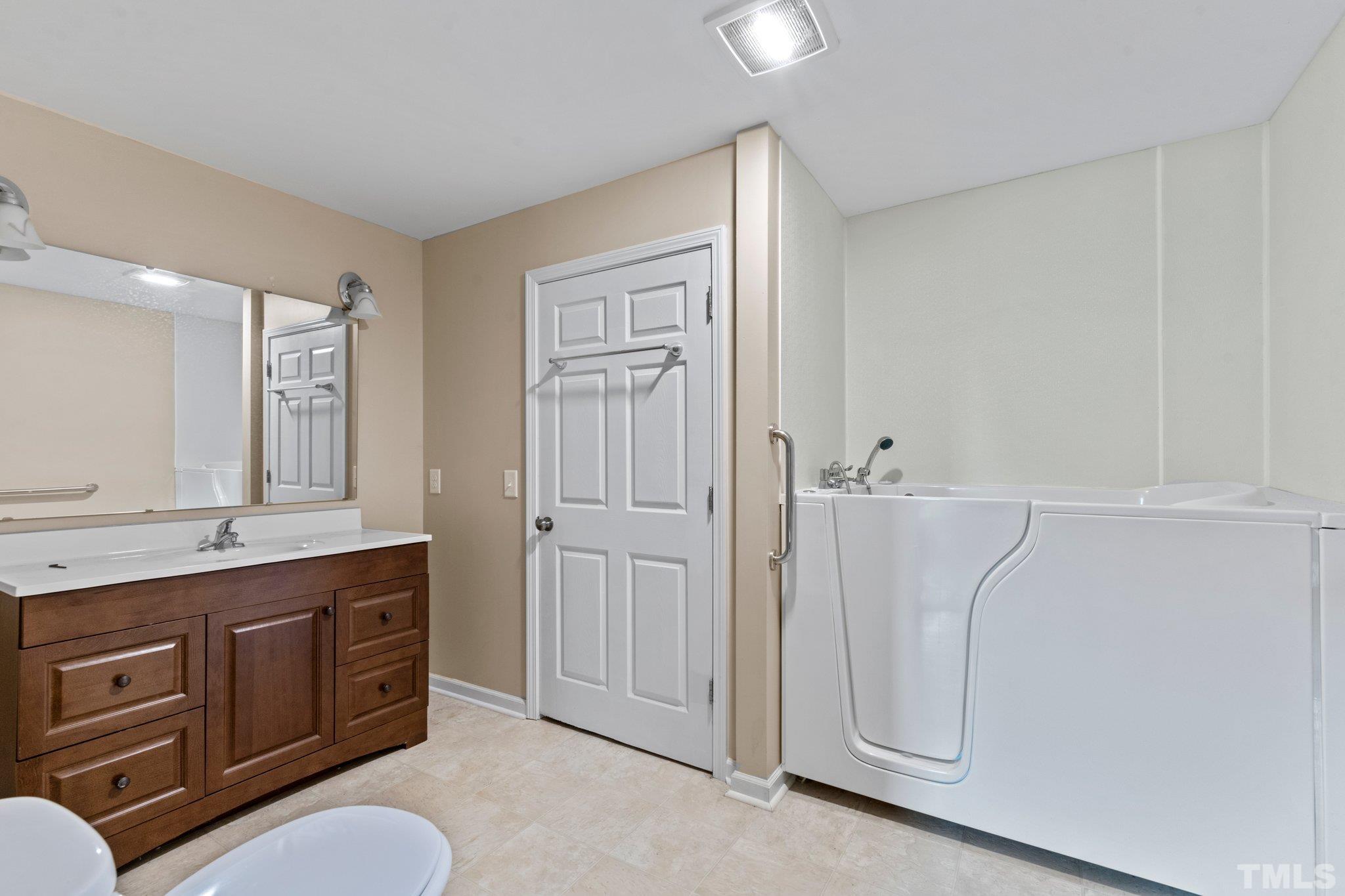 218 Oxford Road Roxboro, NC 27573 - Photo 8 of 16 a spacious bathroom with a double vanity sink a toilet and a mirror