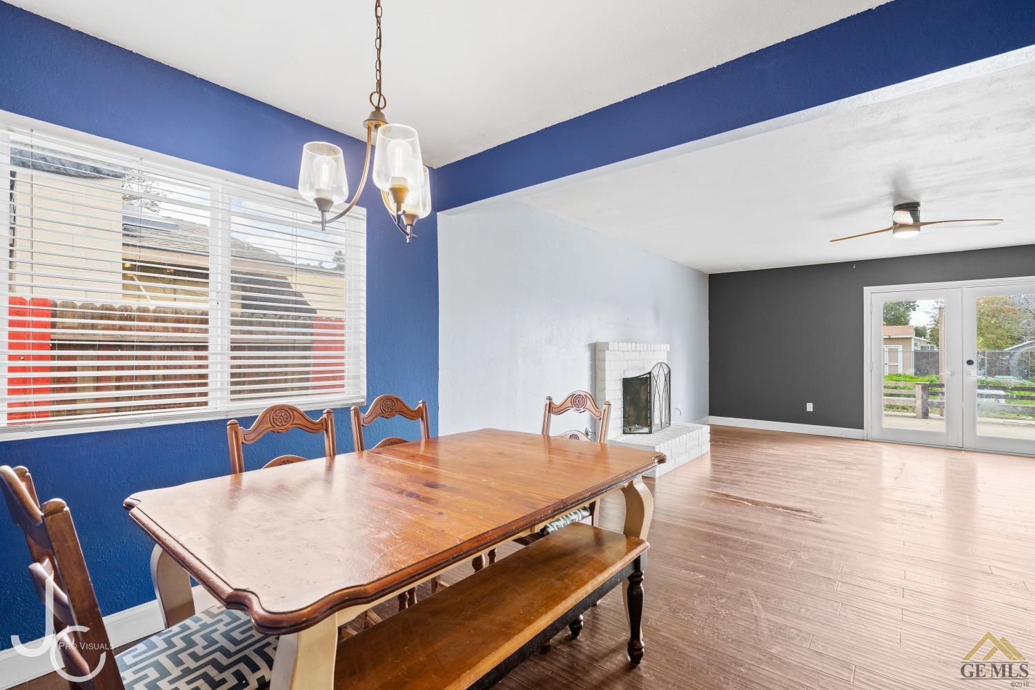 Undisclosed Address Bakersfield, CA 93308 - Photo 5 of 14 a dining room with wooden floor a chandelier a wooden table and chairs