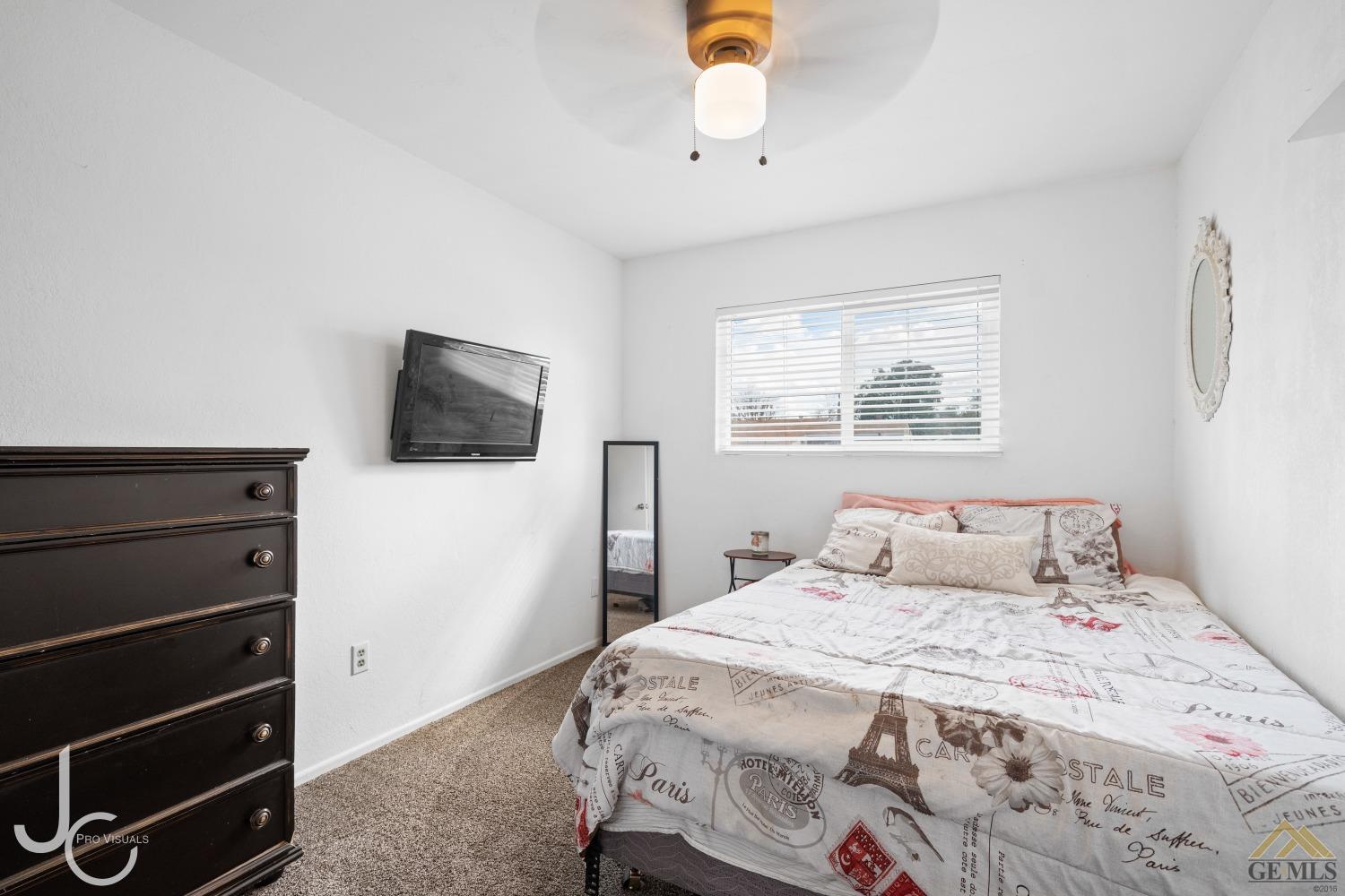 Undisclosed Address Bakersfield, CA 93308 - Photo 8 of 14 a bedroom with a bed and a flat tv screen on dresser