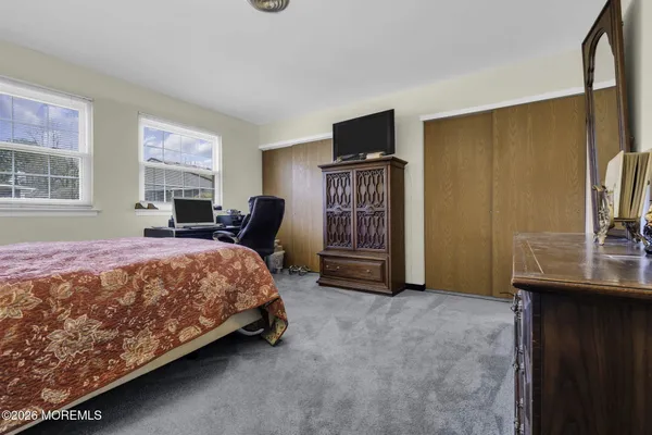 a spacious bedroom with a bed and a flat screen tv
