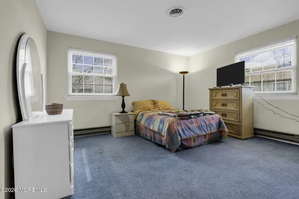 a spacious bedroom with a bed and a flat screen tv