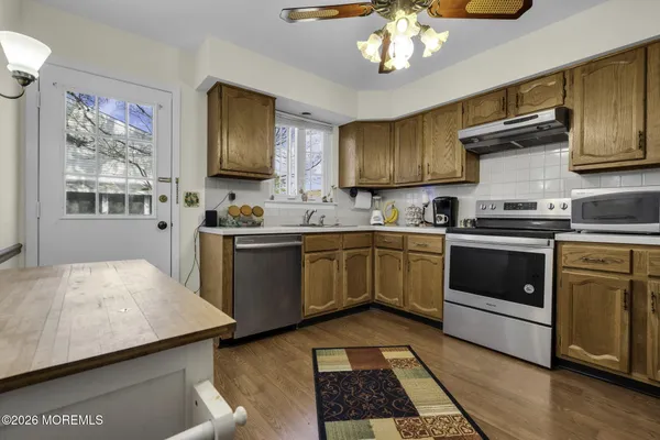 a kitchen with a stove sink and cabinets