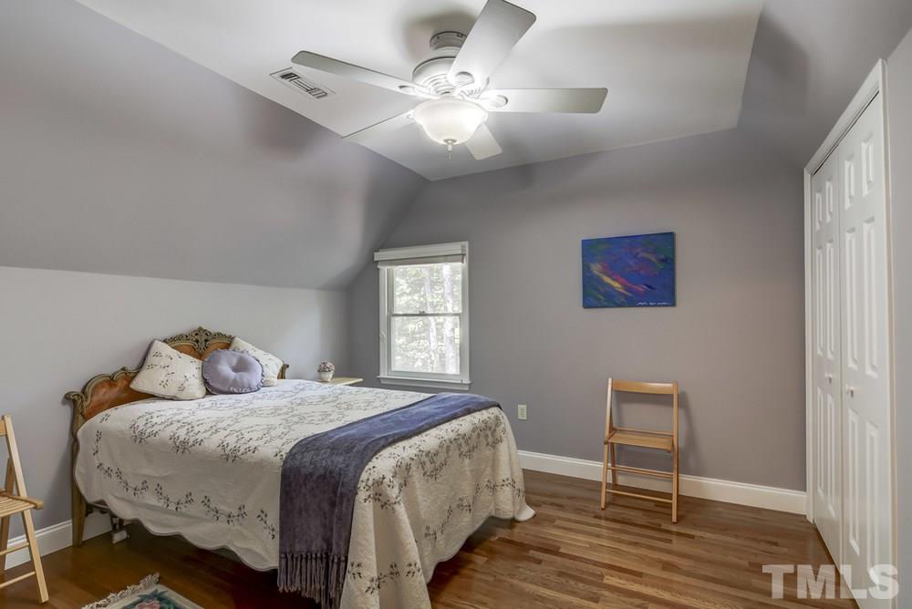 5612 Purnell Road Wake Forest, NC 27587 - Photo 12 of 23 a bedroom with a bed and a chandelier