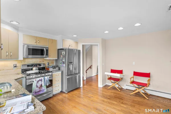 a kitchen with stainless steel appliances kitchen island granite countertop a refrigerator and a stove top oven