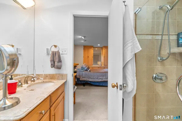 a en suite bathroom with a granite countertop sink and a mirror