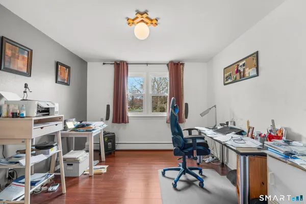 a view of a workspace with furniture and a window