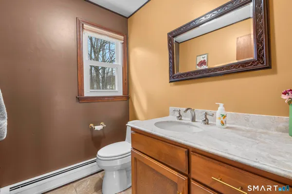 a bathroom with a granite countertop toilet sink and mirror