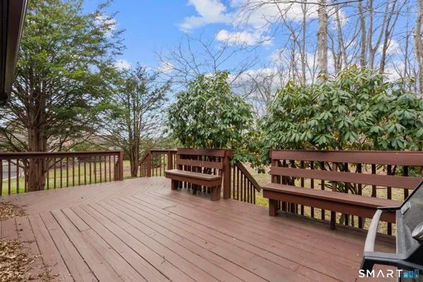 a view of a wooden chairs and bench on the roof deck