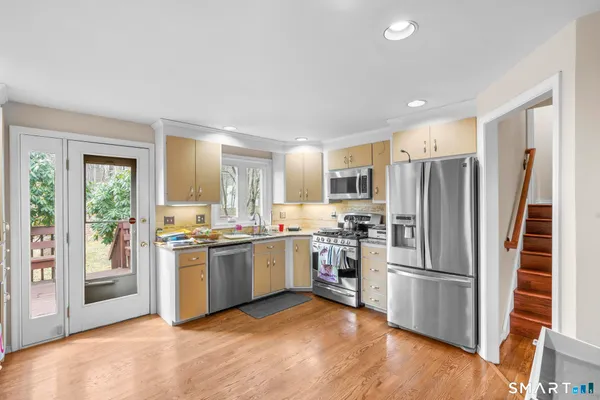 a kitchen with stainless steel appliances granite countertop a refrigerator stove and sink