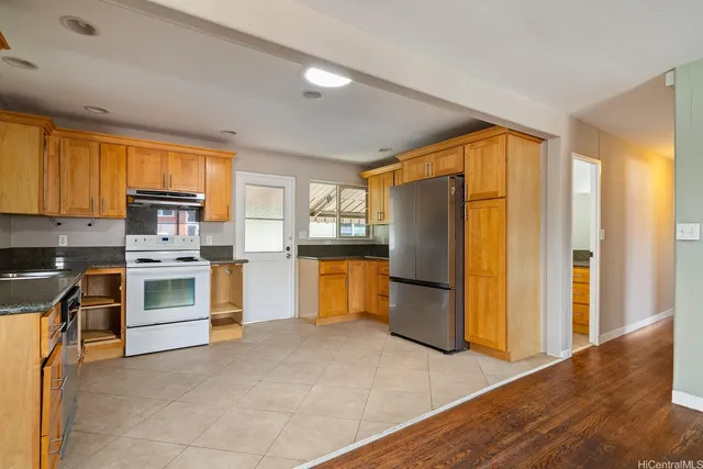 a kitchen with a refrigerator and a stove top oven