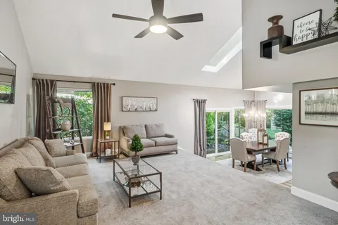 a dining room with furniture a chandelier and wooden floor
