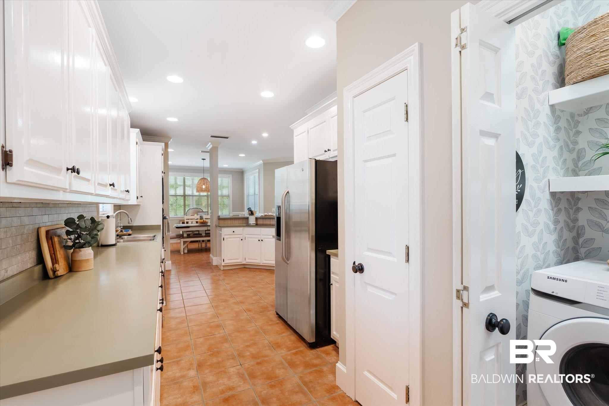 30648 Pine Court Daphne, AL 36527 - Photo 10 of 30 Kitchen with decorative backsplash, white cabinetry, washer / dryer, and stainless steel fridge with ice dispenser