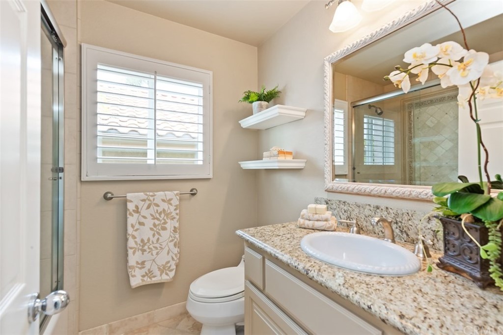 17 St Francis Court Dana Point, CA 92629 - Photo 28 of 66 a bathroom with a granite countertop toilet a sink a shower and a mirror