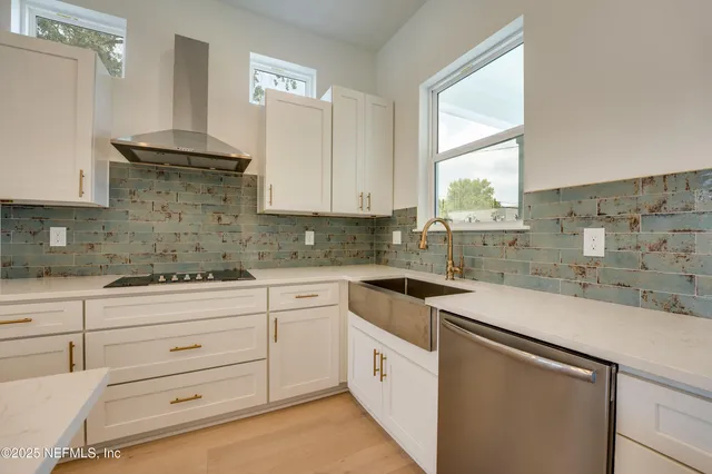 a kitchen with stainless steel appliances granite countertop a large counter top and a wooden floors