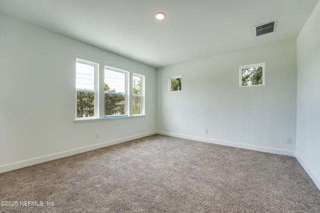 a bedroom with a large bed and a potted plant
