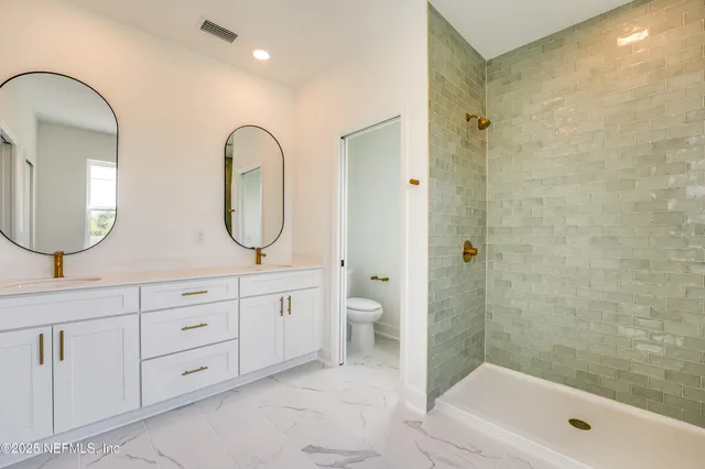 a bathroom with 2 sink toilet and a mirror