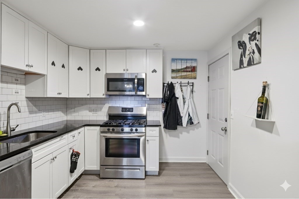 352 Vale Street, Unit 1 Fall River, MA 02724 - Photo 3 of 12 a kitchen with white cabinets and stainless steel appliances
