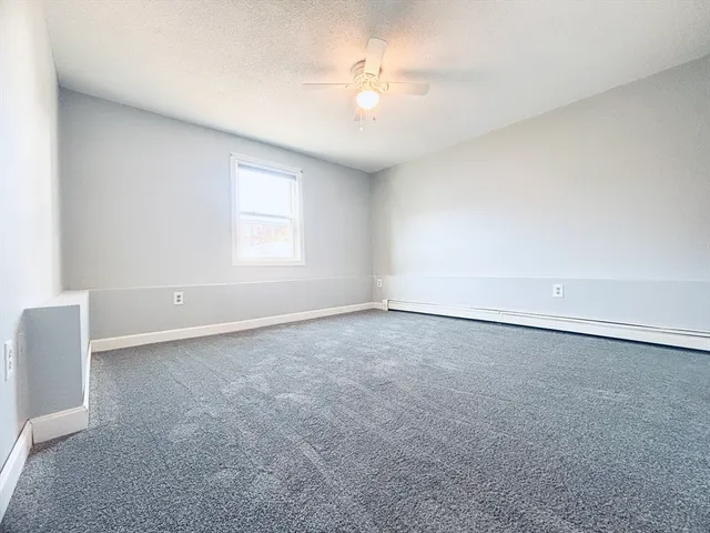 an empty room with a window and a ceiling fan