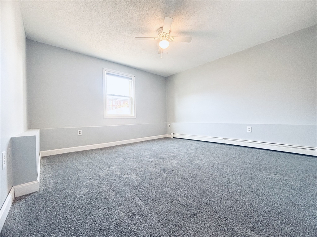 352 Vale Street, Unit 1 Fall River, MA 02724 - Photo 4 of 10 an empty room with a window and a ceiling fan