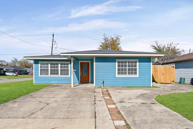 a front view of a house with a yard and potted plants