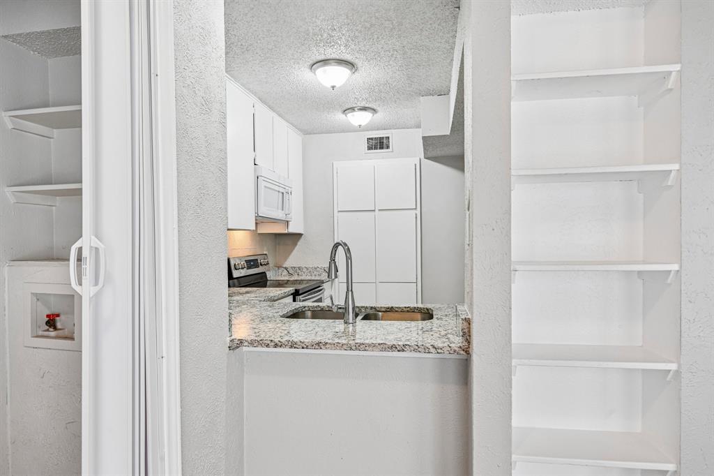 5534 Boca Raton Boulevard, Unit 292 Fort Worth, TX 76112 - Photo 13 of 31 a kitchen with kitchen island a sink appliances and cabinets