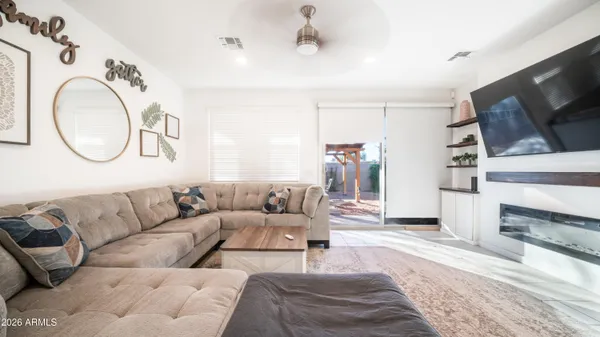 a living room with furniture a flat screen tv and a fireplace