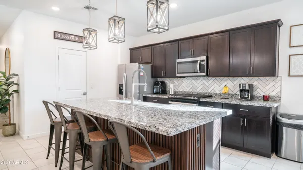 a kitchen with granite countertop a table chairs stove and cabinets