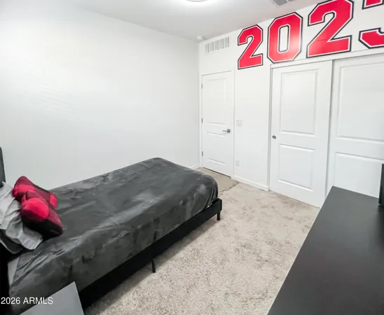 a bedroom with a bed and a white cabinet
