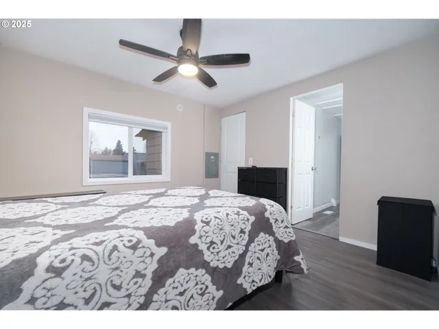 a bedroom with a bed and wooden floor