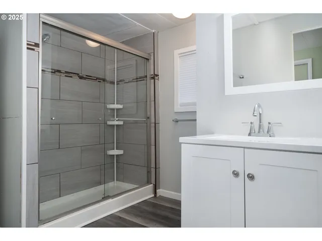 a bathroom with a shower sink and mirror