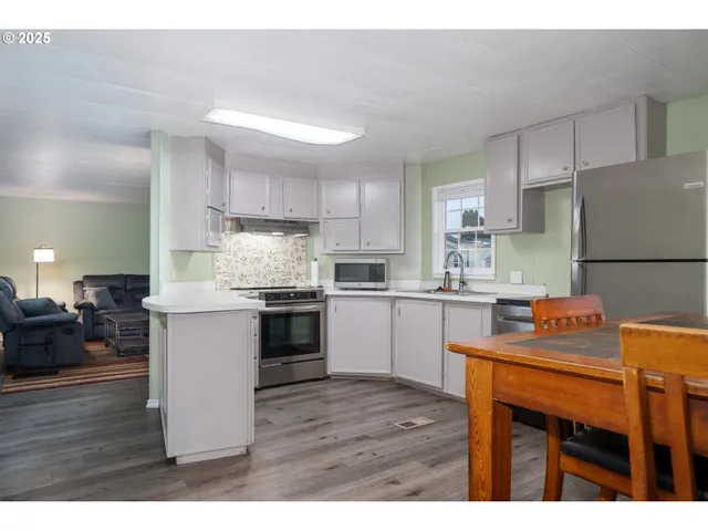 a kitchen with stainless steel appliances granite countertop a refrigerator a sink dishwasher a stove with wooden cabinets