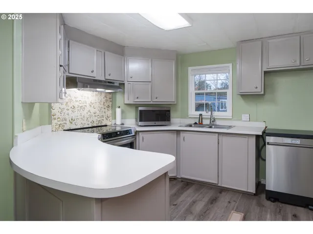 a kitchen with kitchen island granite countertop a sink a stove and cabinets