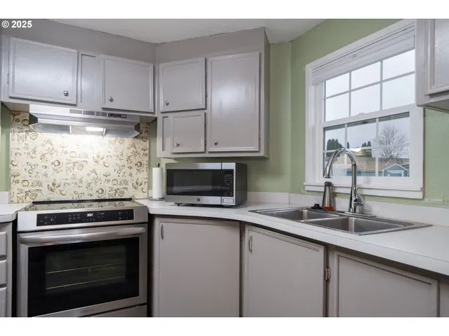a kitchen with stainless steel appliances a stove a sink and a microwave