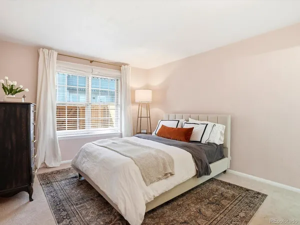 a large bed sitting in a bedroom next to a window and a dresser