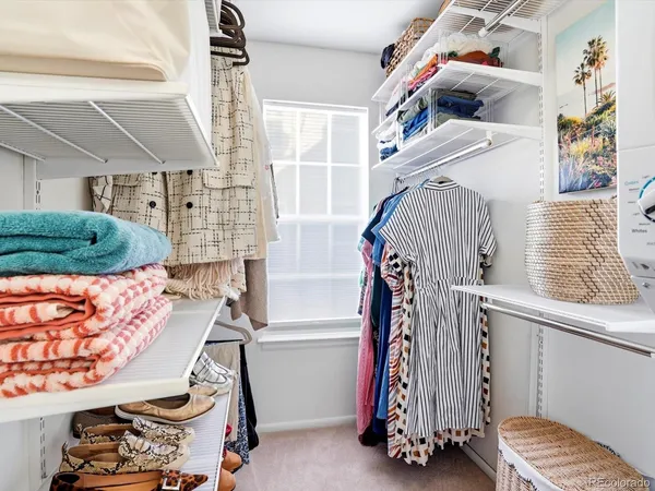 a view of walk in closet with clothes and shoes