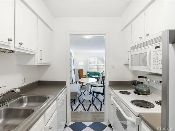 a kitchen that has a sink and white cabinets