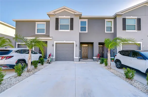 a front view of a house with garden and parking