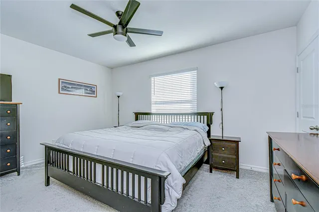 a bedroom with a large bed a chandelier and a window